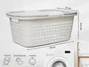 A white laundry basket with gray accents is shown with dimensions and feature icons below. A washing machine is visible in the background. Produktbild-Vorschau