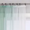 A close-up view of sheer curtains hanging from a curtain rod. Produktbild-Vorschau