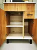An open cabinet with shelves and a drawer, showcasing the interior. Náhled obrázku produktu