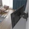 A television mounted on a wall with a wall mount, in a living room setting with a chair and curtains. Anteprima dell’immagine prodotto
