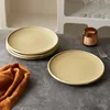 A stack of plates and a single plate on a textured surface, with a folded cloth and a candle jar. Produktbild-Vorschau