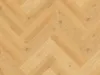 A close-up, top-down view of a herringbone-patterned wood floor. Produktbild-Vorschau