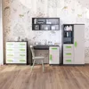 A child's bedroom set with a dresser, desk, and cabinet against a wall with a woodland-themed wallpaper. Produktbild-Vorschau