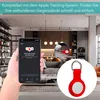 A hand holding a smartphone displaying an app, with a living room and kitchen in the background. A red AirTag case is shown in a close-up inset. Produktbild-Vorschau