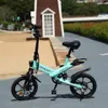 A light blue electric bicycle is parked on a paved path in an outdoor setting with a sandy area and greenery in the background. Produktbild-Vorschau