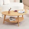 A wooden coffee table with a vase, cherries, and a magazine on it, placed in a living room setting. Voir les images du produit