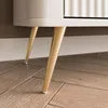 Close-up of the legs and bottom of a beige TV cabinet. Produktbild-Vorschau