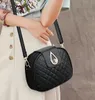 A person is wearing a black quilted crossbody bag. Náhled obrázku produktu