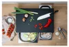 A cutting board with various ingredients and a knife laid out on a wooden surface. Voir les images du produit