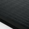 A close-up view of a black pleated blind with horizontal lines. Produktbild-Vorschau