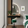 A modern bedroom vanity area with a dressing table, illuminated mirror, and stool. Produktbild-Vorschau