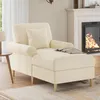A beige chaise lounge is placed in a living room setting next to a fireplace. Náhled obrázku produktu
