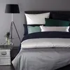 A neatly made bed with multiple pillows and a duvet. Produktbild-Vorschau