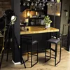 A modern bar area with two black bar stools, a wooden countertop, and industrial-style shelving. Anteprima dell’immagine prodotto