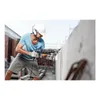 A construction worker is using a rotary hammer drill on a concrete wall. Podgląd zdjęcia produktu