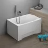 A white bathtub with a white panel and a shower head attached to a tiled wall, with a wooden cabinet and a blue toy in the foreground. Podgląd zdjęcia produktu
