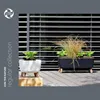 Two planters with plants on a wooden deck in front of blinds. Náhľad obrázku produktu
