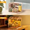 A split image showing a miniature kitchen model in daylight and nighttime settings. Podgląd zdjęcia produktu