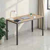 A desk with a laptop, lamp, and plant. Voir les images du produit