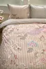 A close-up view of a bedding set with a floral and bird pattern. Produktbild-Vorschau