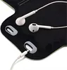 A close-up view of white earbuds and their charging cable connected to a black armband. Produktbild-Vorschau