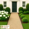 A pathway leading to a dark green front door, flanked by manicured bushes and a large white hydrangea bush. The pathway is made of light brown gravel. Produktbild-Vorschau