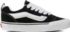 A side view of a black Vans sneaker with white laces and a white sole. Voir les images du produit