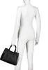 A mannequin wearing a white long-sleeved shirt and white pants, holding a black handbag. Voir les images du produit