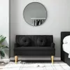 A black sofa with two round cushions is placed in a room with a large circular mirror on the wall. Podgląd zdjęcia produktu