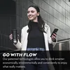 A woman is holding a travel mug and a smartphone while walking down stairs. Podgląd zdjęcia produktu