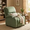 A green recliner chair in a living room setting, with a bookshelf and window in the background. Voir les images du produit