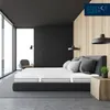 A modern bedroom with a large window, a bed with a mattress and pillows, and a side table with a plant. Produktbild-Vorschau