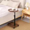 A small round table with a cup and a small plate of snacks on it, placed next to a bed. Produktbild-Vorschau