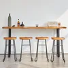 A set of four bar stools in front of a wooden bar counter against a white wall. Produktbild-Vorschau