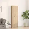 A tall, narrow wardrobe with two doors stands against a plain wall, next to a potted plant. A sofa and a small side table with a vase and a cup are visible on the left. Produktbild-Vorschau