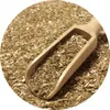 A close-up view of dried mate tea leaves being scooped with a wooden spoon. Produktbild-Vorschau