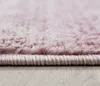 Close-up of the edge of a pink rug with a subtle pattern, resting on a light wooden floor. Podgląd zdjęcia produktu