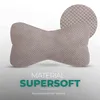 A bone-shaped pillow with a textured fabric is shown against a gradient background. A magnified view of the fabric texture is visible in the upper right corner. Text overlays provide product information. Produktbild-Vorschau