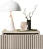 A white table lamp, a glass of water, and a vase with branches are placed on a bedside table. Produktbild-Vorschau