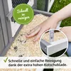 A hand is shown cleaning out a pet enclosure with wood shavings, highlighting the ease of cleaning. Produktbild-Vorschau