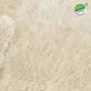 Close-up of a fluffy, cream-colored sheepskin rug. Voir les images du produit