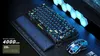 A gaming keyboard and mouse set with RGB lighting, displayed on a desk mat with some decorative hexagonal lights in the background. Produktbild-Vorschau