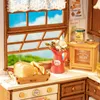 A miniature kitchen scene with a window, bread, flowers, and kitchen accessories. Náhľad obrázku produktu