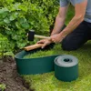 A person is kneeling in a garden, using a mallet to install green garden edging. Produktbild-Vorschau
