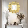 A decorative wall clock is mounted on a white wall above a console table with floral arrangements and decorative objects. Voir les images du produit