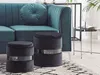 A living room scene with a teal sofa, two black poufs, and a side table. Náhled obrázku produktu