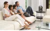 A family is sitting on a couch watching TV, with a portable speaker on a side table. Podgląd zdjęcia produktu