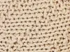 A close-up view of a beige knitted pouf. Náhled obrázku produktu