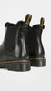 A close-up rear view of two black Dr. Martens Chelsea boots with faux fur trim. Produktbild-Vorschau