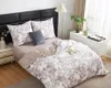 A bedroom scene with a neatly made bed, nightstand, and lamp. Podgląd zdjęcia produktu